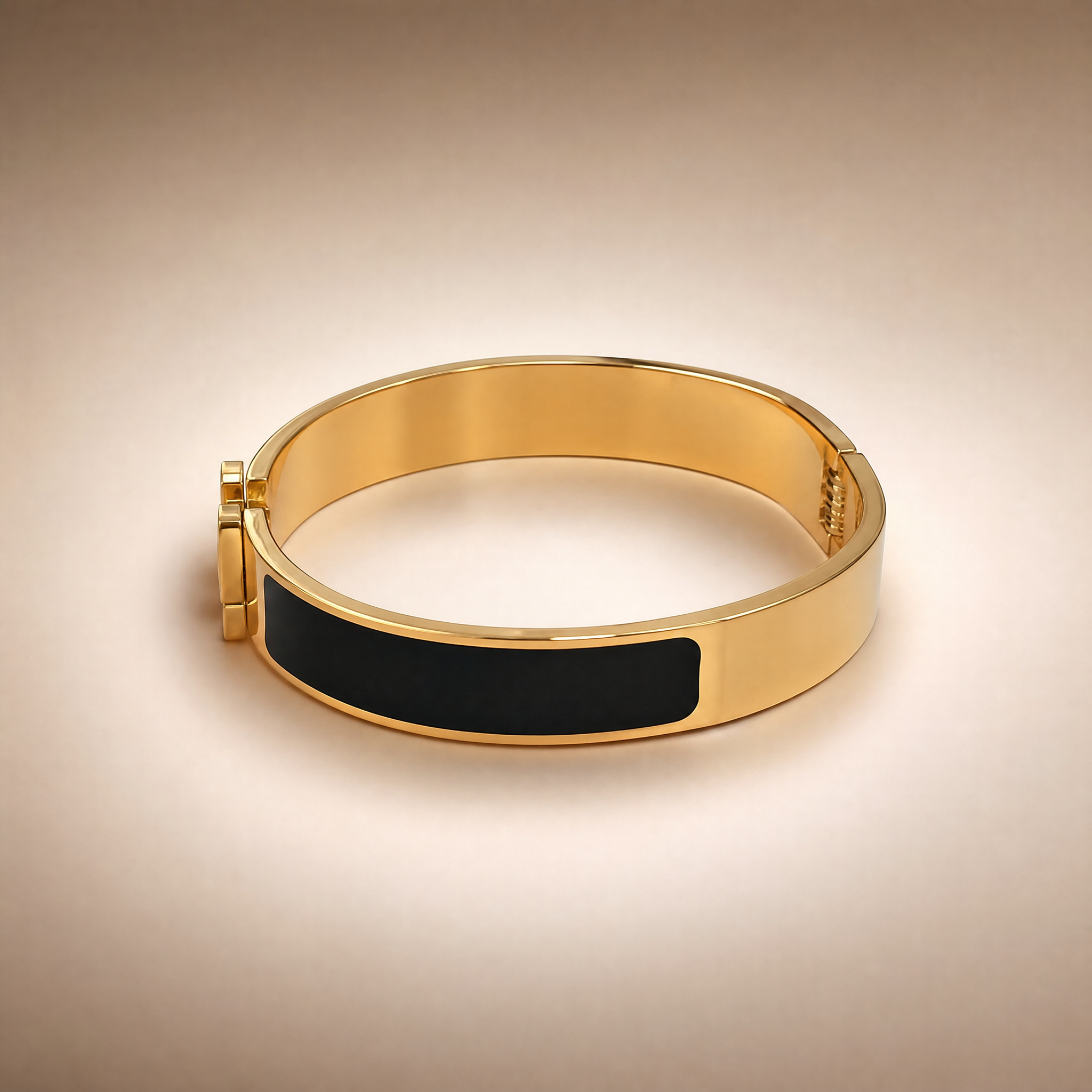 Gold hinged bangle with black enamel inlay