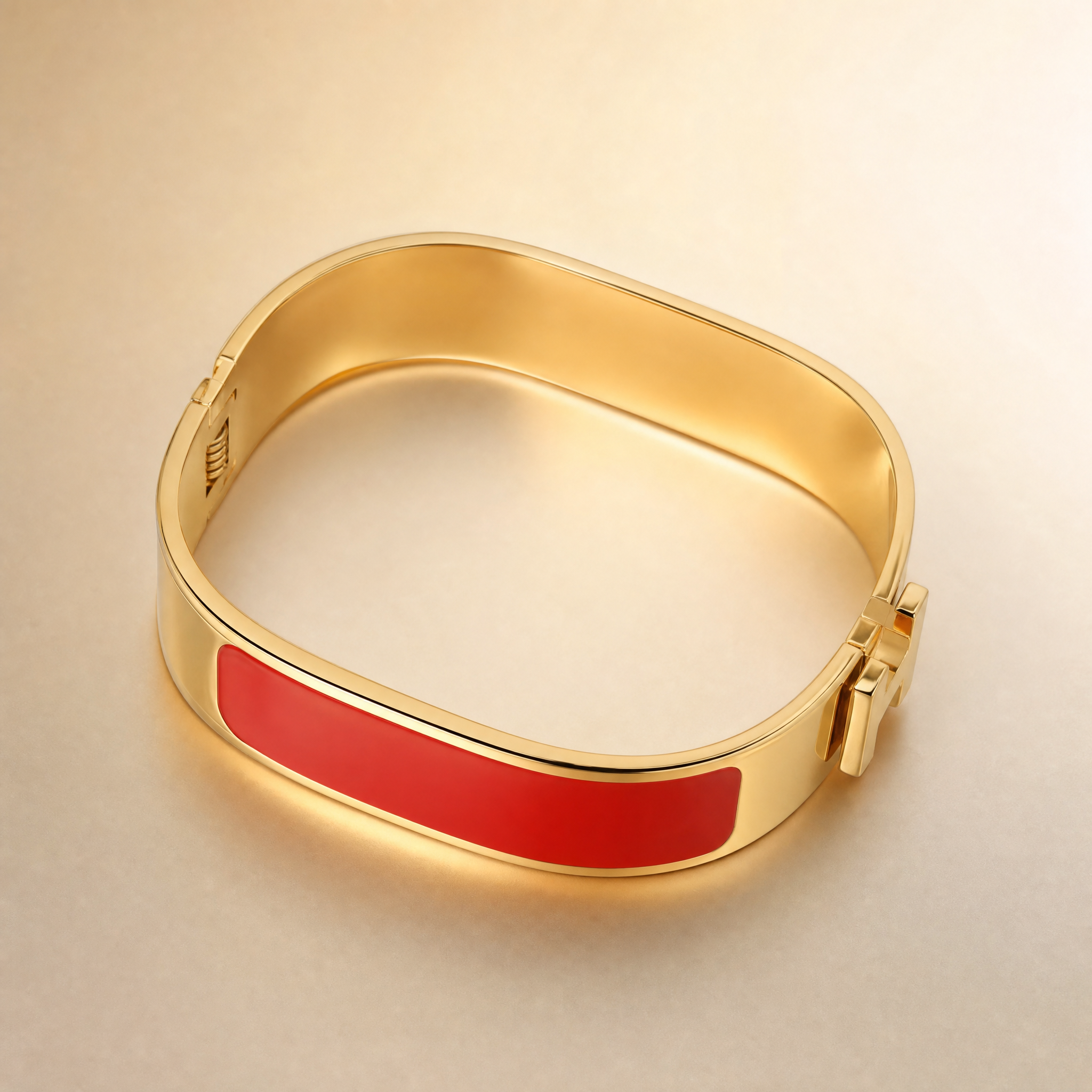 Gold hinged bangle with red enamel inlay