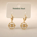 Gold huggie drops, CZ evil-eye charm, scalloped frame